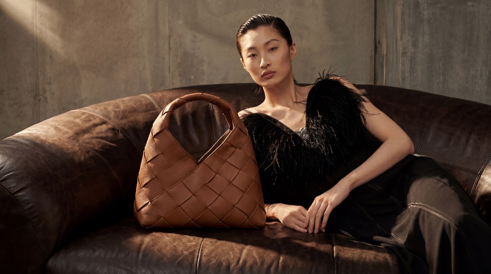 AI campaign: model with a woven leather handbag in a brutalist interior